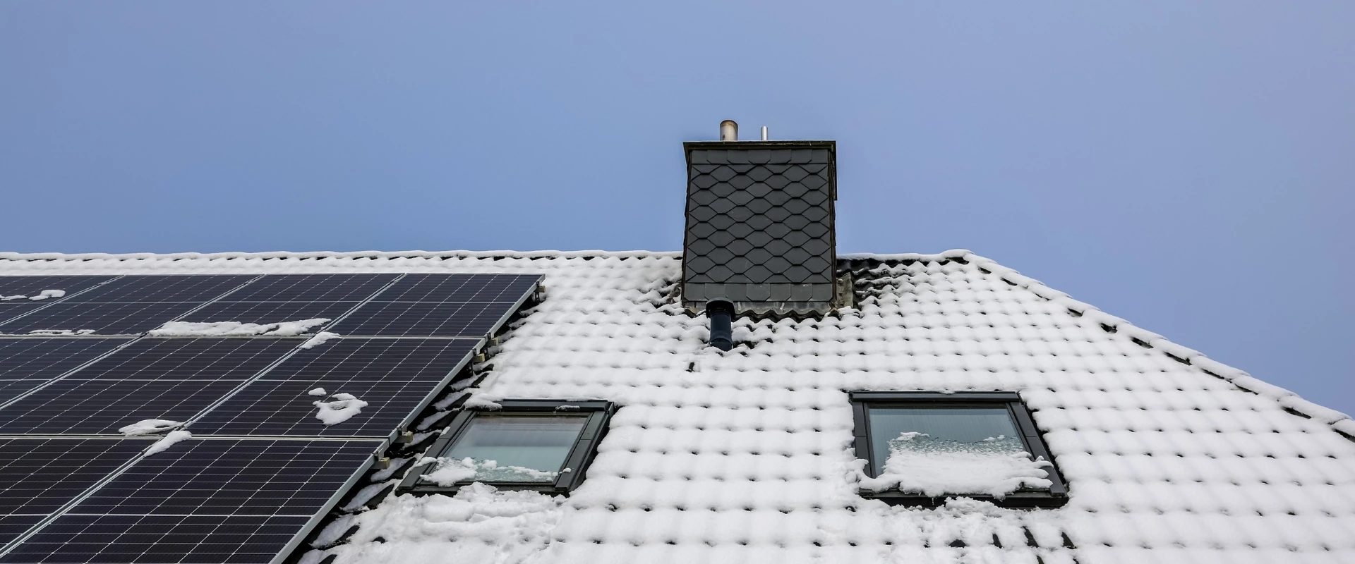 Solar panels on a snow covered residential roof in winter light