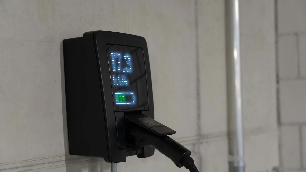 A wall mounted Level 2 EV charging unit with its cable coiled