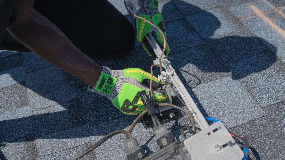 An installer securing a solar panel to roof racking
